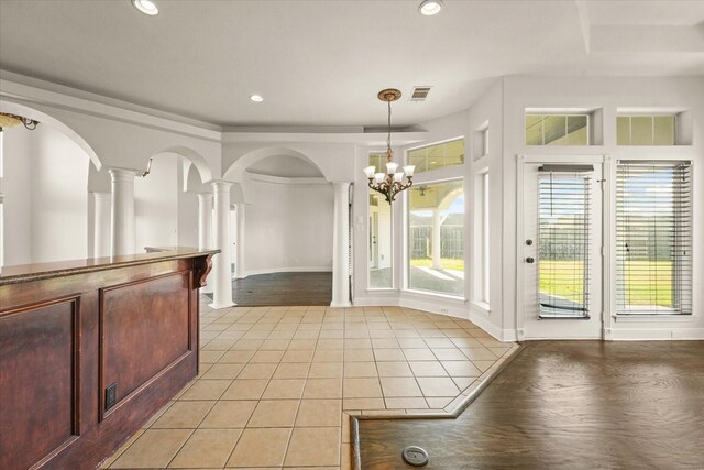 153 Whispering Winds Dr, Gunter, TX 75058 - unfurnished dining area with decorative columns, light tile patterned floors, a chandelier, recessed lighting, and arched walkways
