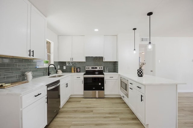 2112 Pontiac Dr, Carrollton, TX 75006 - kitchen featuring light wood-type flooring, a sink, visible vents, a peninsula, and appliances with stainless steel finishes