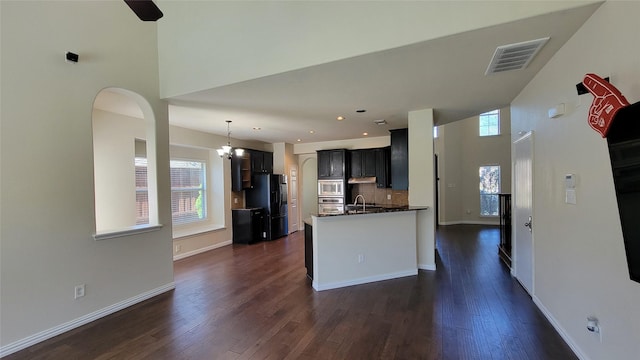 kitchen featuring visible vents, dark wood finished floors, tasteful backsplash, appliances with stainless steel finishes, and a sink