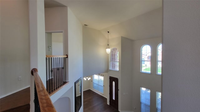 foyer with baseboards, high vaulted ceiling, and dark wood-style flooring