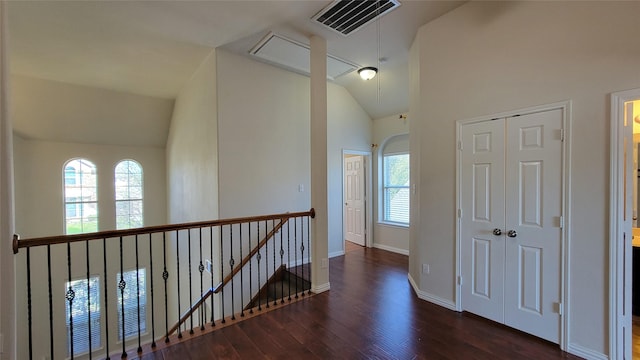 hall featuring an upstairs landing, visible vents, baseboards, wood finished floors, and attic access