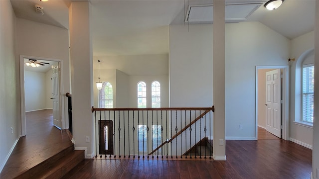hallway featuring an upstairs landing, attic access, and wood finished floors
