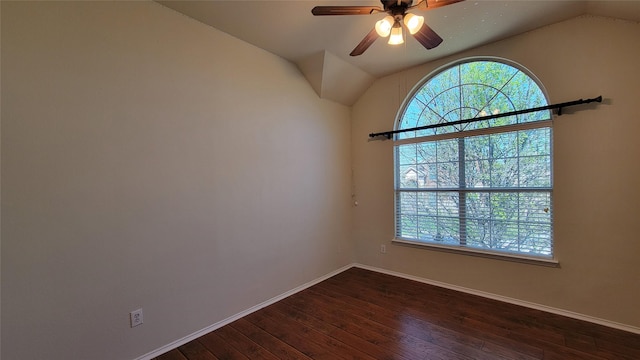 empty room featuring lofted ceiling, a healthy amount of sunlight, a ceiling fan, and dark wood finished floors