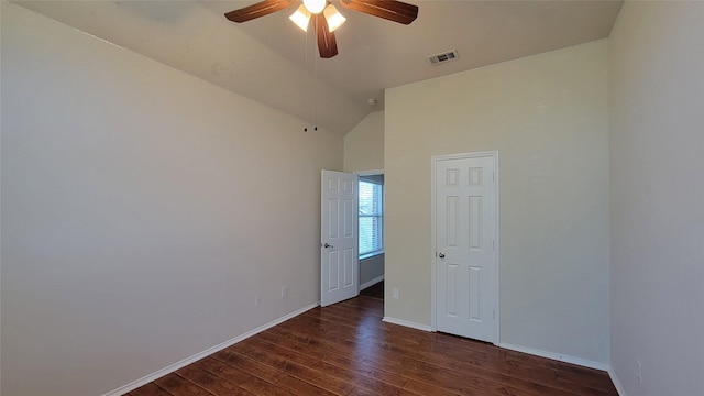 empty room with vaulted ceiling, baseboards, visible vents, a ceiling fan, and wood finished floors