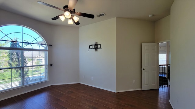 spare room featuring wood-type flooring, a ceiling fan, baseboards, and visible vents