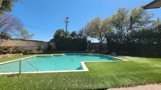 view of swimming pool with a fenced in pool, a fenced backyard, and a yard
