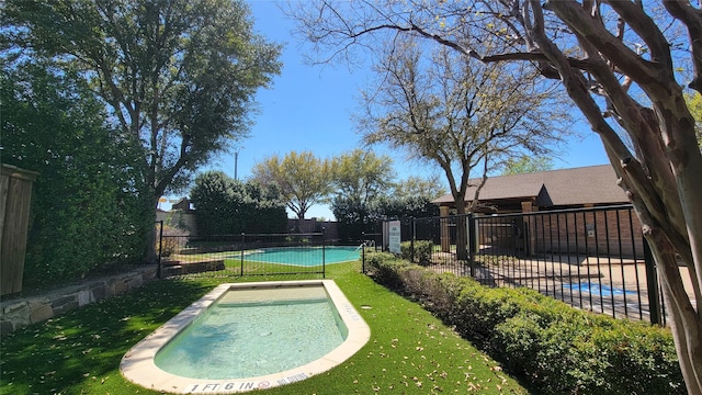 view of swimming pool featuring fence and a yard