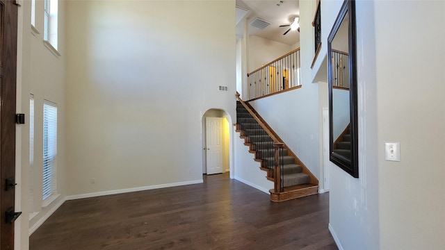 interior space with stairs, arched walkways, ceiling fan, visible vents, and wood finished floors