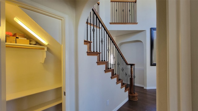 staircase featuring baseboards and wood finished floors