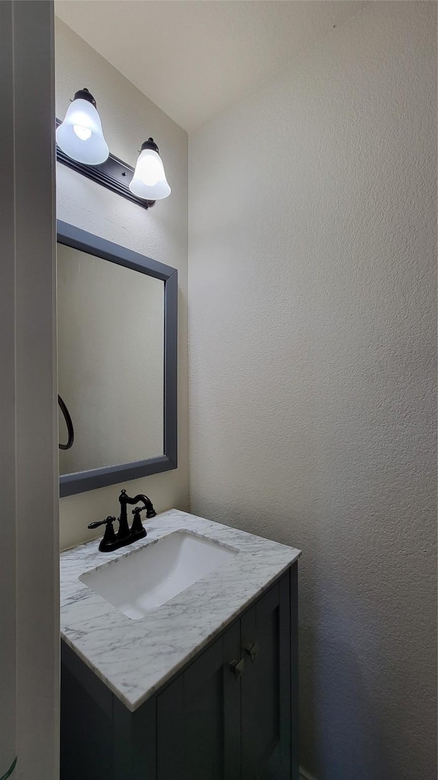 bathroom with a textured wall and vanity