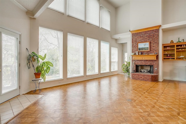 1002 Loch Lomond Dr, Arlington, TX 76012 - unfurnished living room featuring baseboards, a high ceiling, a brick fireplace, and plenty of natural light