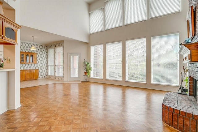 1002 Loch Lomond Dr, Arlington, TX 76012 - living area with baseboards, wallpapered walls, a high ceiling, and a brick fireplace