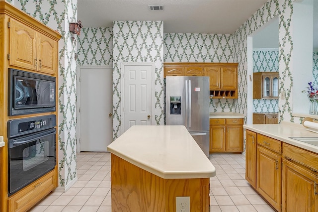 1002 Loch Lomond Dr, Arlington, TX 76012 - kitchen with visible vents, wallpapered walls, black appliances, a center island, and light tile patterned floors