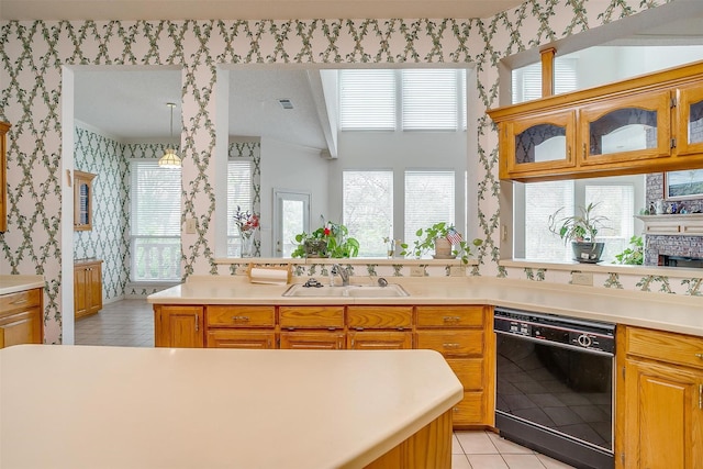 1002 Loch Lomond Dr, Arlington, TX 76012 - kitchen with light countertops, wallpapered walls, black dishwasher, glass insert cabinets, and a sink