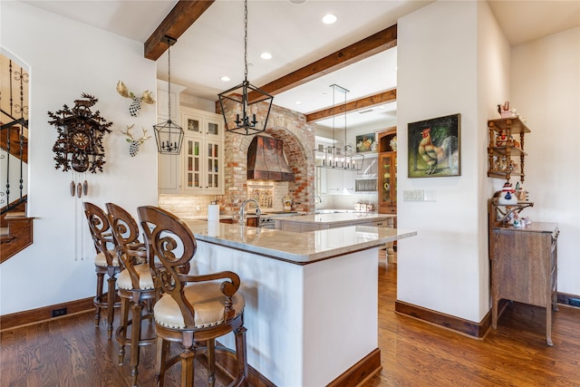 kitchen with beamed ceiling, dark wood-style flooring, custom exhaust hood, backsplash, and baseboards