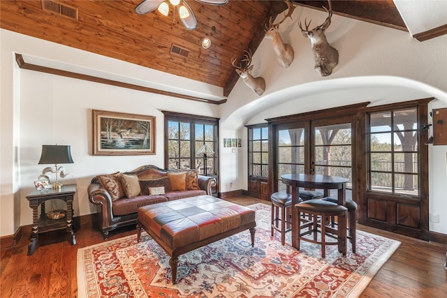 living area with lofted ceiling, visible vents, a ceiling fan, and wood finished floors