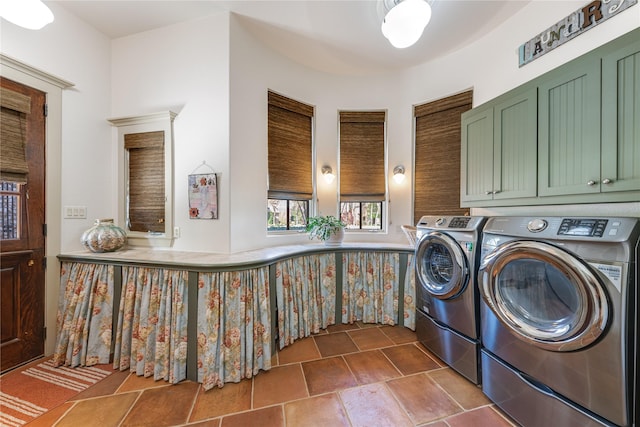 laundry room featuring separate washer and dryer, cabinet space, and stone finish floor