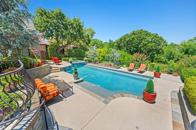view of swimming pool featuring fence, a pool with connected hot tub, and a patio