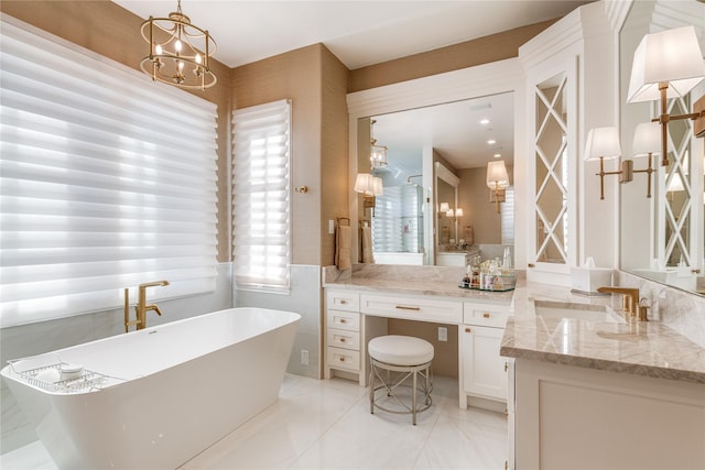 bathroom featuring a soaking tub, a chandelier, and vanity