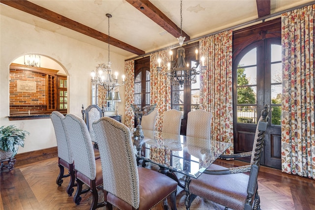 dining room featuring beamed ceiling, a chandelier, arched walkways, baseboards, and french doors