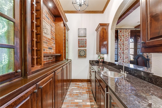 bar with crown molding, arched walkways, a sink, and baseboards