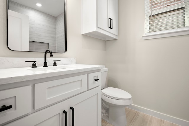 bathroom with baseboards, toilet, and vanity