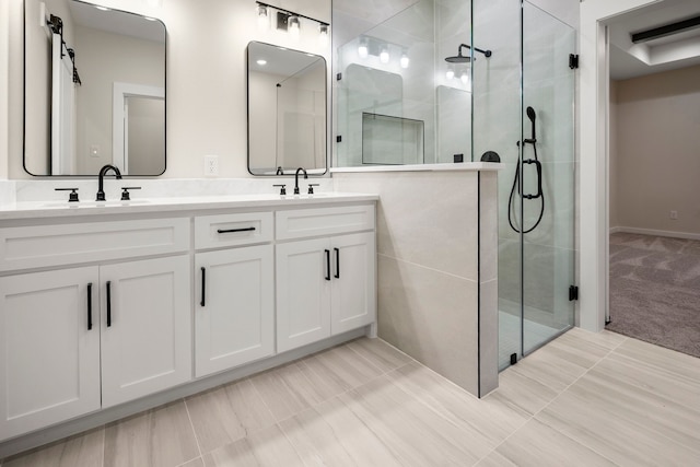 bathroom featuring double vanity, a sink, and a shower stall
