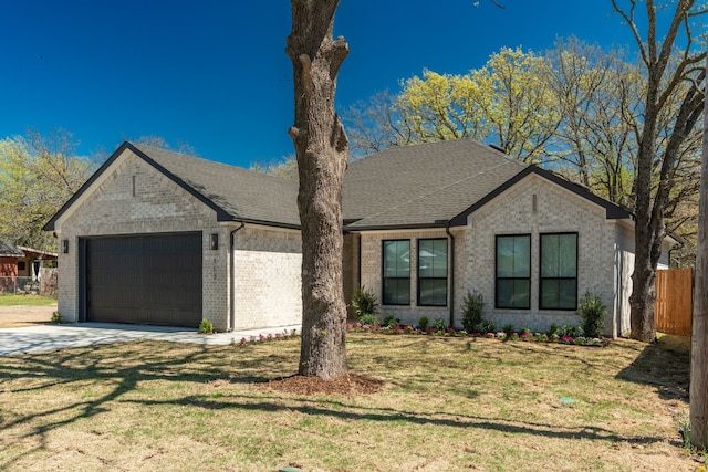 view of front of house featuring fence, an attached garage, driveway, a front yard, and brick siding