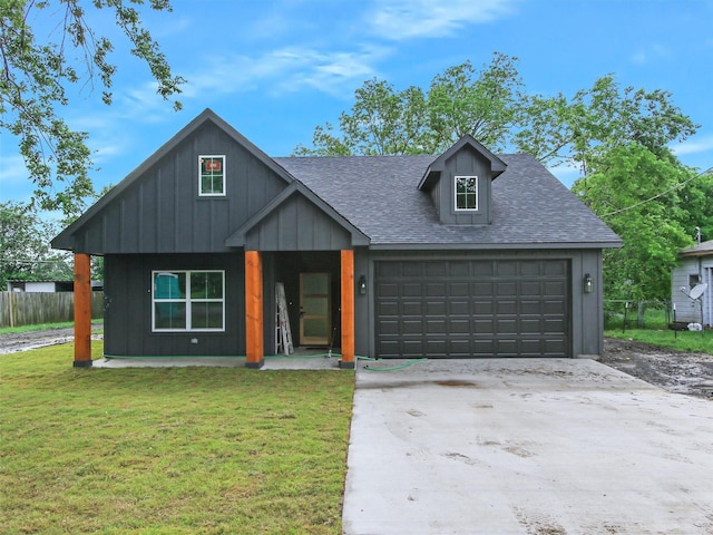 view of front of house with fence, a shingled roof, a front lawn, board and batten siding, and driveway