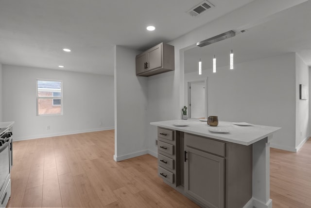 2225 Mack Ln, Dallas, TX 75227 - kitchen with gray cabinets, light wood-style flooring, stainless steel range with electric stovetop, recessed lighting, and hanging light fixtures