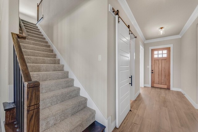 4133 Old Springtown Rd, Weatherford, TX 76085 - entryway featuring baseboards, stairs, ornamental molding, a barn door, and light wood-type flooring