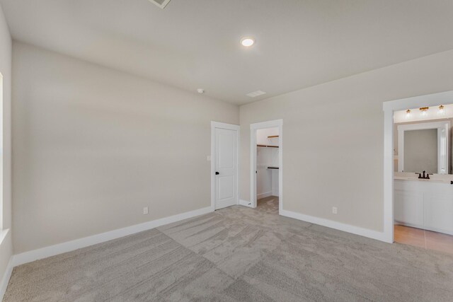 4133 Old Springtown Rd, Weatherford, TX 76085 - unfurnished bedroom with light carpet, ensuite bath, baseboards, and a walk in closet
