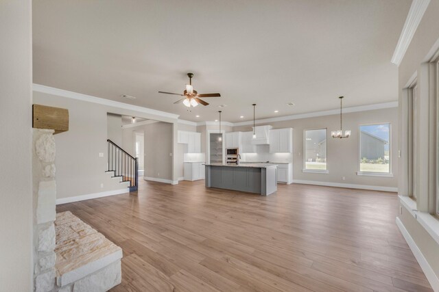 4133 Old Springtown Rd, Weatherford, TX 76085 - living room with baseboards, light wood-style flooring, stairway, and ceiling fan with notable chandelier