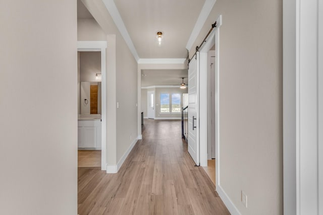 4133 Old Springtown Rd, Weatherford, TX 76085 - hallway featuring baseboards, a barn door, ornamental molding, and light wood-type flooring