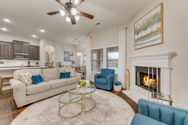 living room featuring visible vents, arched walkways, recessed lighting, and dark wood finished floors