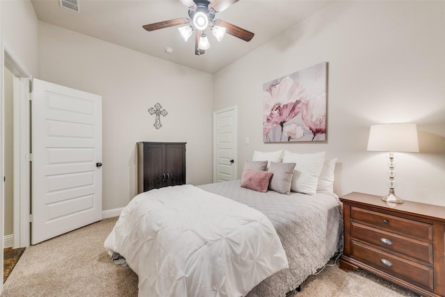 carpeted bedroom with visible vents, baseboards, and ceiling fan
