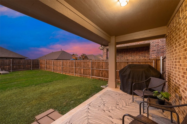 yard at dusk featuring a fenced backyard