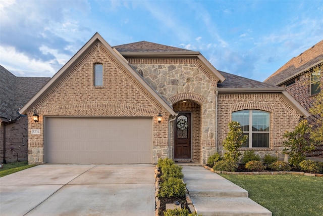 view of front of home featuring stone siding, a shingled roof, driveway, and brick siding