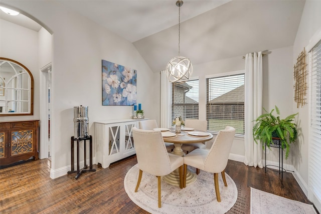 dining space with arched walkways, vaulted ceiling, dark wood-type flooring, and baseboards