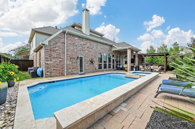 view of swimming pool with a patio area, a pool with connected hot tub, and fence