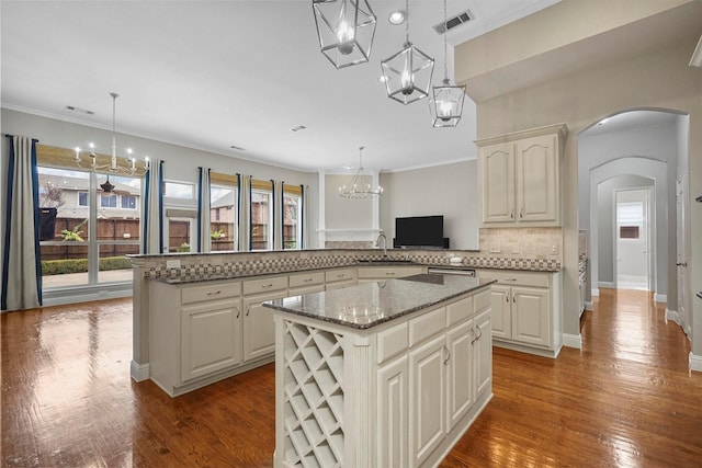 kitchen featuring a peninsula, visible vents, an inviting chandelier, and a kitchen island
