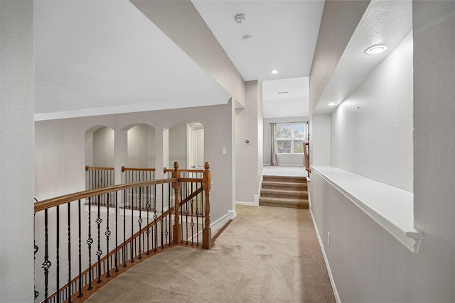 corridor featuring light colored carpet, recessed lighting, an upstairs landing, and baseboards