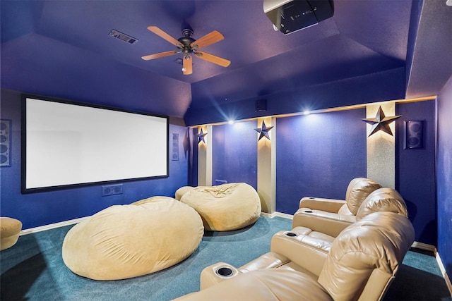 carpeted cinema room featuring baseboards, lofted ceiling, ceiling fan, and visible vents