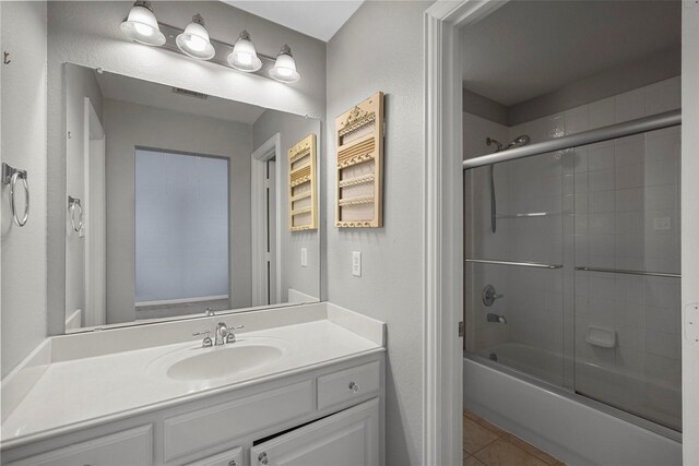 full bath with combined bath / shower with glass door, visible vents, tile patterned flooring, and vanity