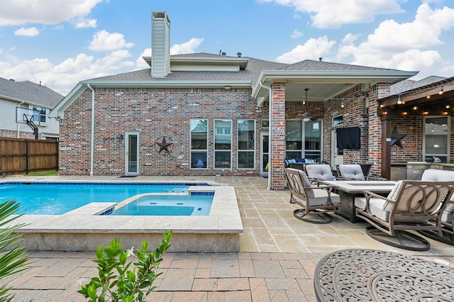 view of swimming pool with fence, a pool with connected hot tub, and a patio area