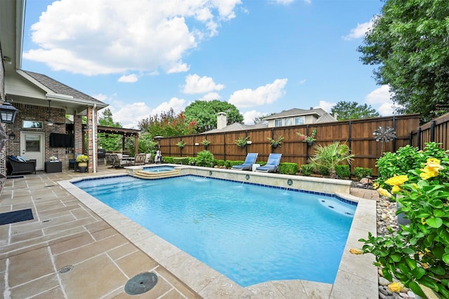 view of swimming pool with a fireplace, a fenced backyard, a pool with connected hot tub, and a patio area