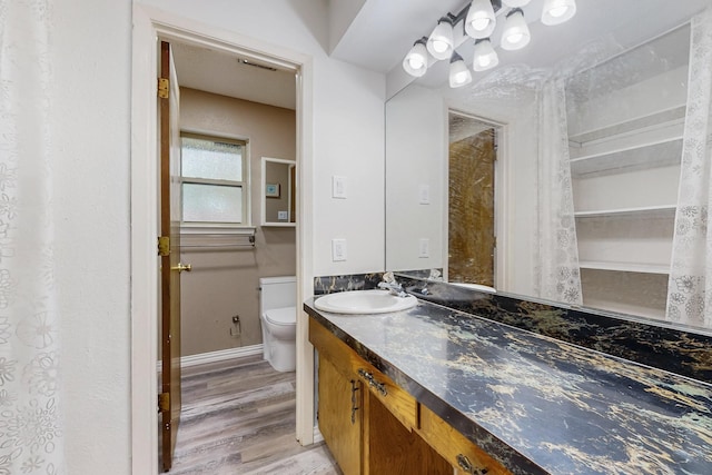 623 Middale Rd, Duncanville, TX 75116 - full bath featuring vanity, toilet, wood finished floors, and baseboards