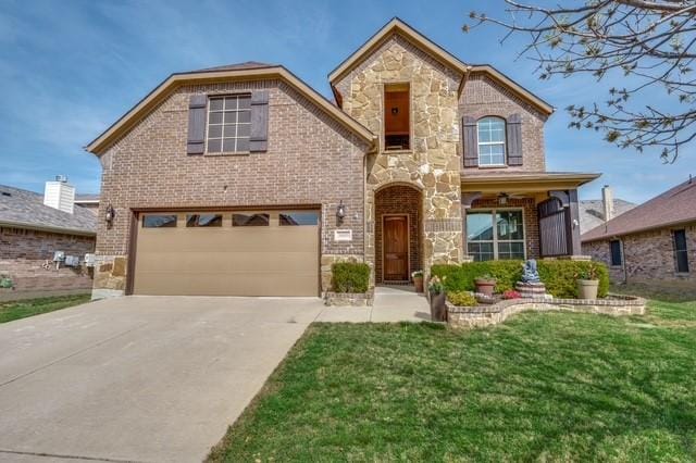 3009 Morning Star Dr, Little Elm, TX 75068 - view of front of home featuring stone siding, an attached garage, a front yard, brick siding, and driveway