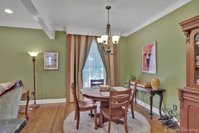 dining area with light wood finished floors, a notable chandelier, ornamental molding, and baseboards
