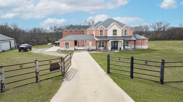 view of front facade with a front lawn, driveway, a fenced front yard, and brick siding